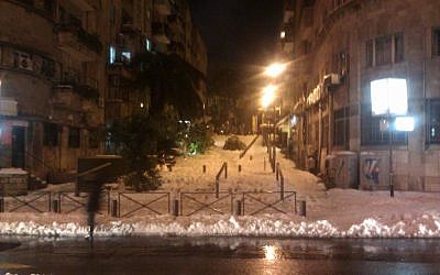 Jerusalem's Shatz Street pedestrian mall covered in snow and downed tree limbs, Saturday night, December 14, 2013 (photo credit: Ilan Ben Zion/Times of Israel)