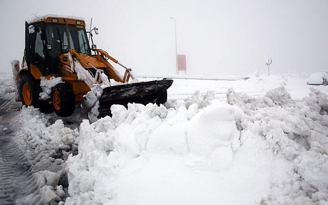 A tractor plows snow on the road at the Al Hader intersection in the West Bank, Saturday, December 14, 2013. (photo credit: Nati Shohat/Flash 90)
