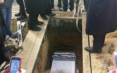 This photo of a special service at New Montefiore Cemetery in West Babylon, New York, shows damaged Torah scroll fragments being buried in a religious ceremony on Sunday (photo credit: AP)