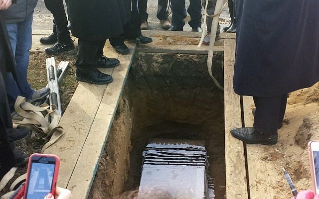 This photo of a special service at New Montefiore Cemetery in West Babylon, New York, shows damaged Torah scroll fragments being buried in a religious ceremony on Sunday (photo credit: AP) This photo of a special service at New Montefiore Cemetery in West Babylon, New York, shows damaged Torah scroll fragments being buried in a religious ceremony on Sunday (photo credit: AP)