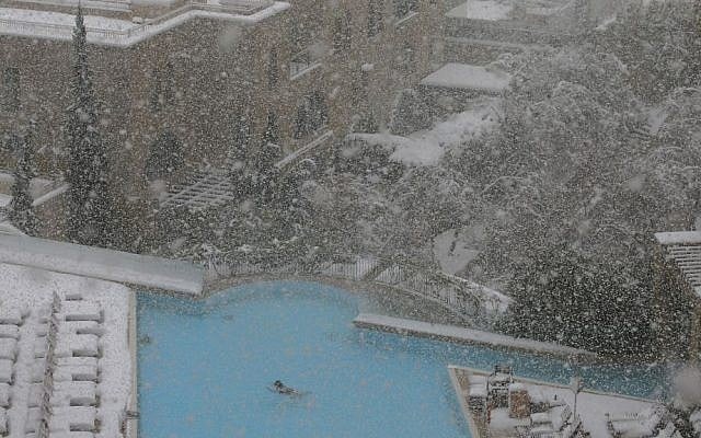 A woman swims in the pool at the David Citadel Hotel during a snowstorm in Jerusalem, Friday, December 13, 2013. (photo credit: AP/Brian Snyder, Pool) A woman swims in the pool at the David Citadel Hotel during a snowstorm in Jerusalem, Friday, December 13, 2013. (photo credit: AP/Brian Snyder, Pool)