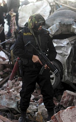 An Egyptian policeman stands guard at the site of an explosion at a police headquarters building in the Nile Delta city of Mansoura, 110 kilometers (70 miles) north of Cairo, Egypt, Tuesday, December 24, 2013. (photo credit: AP/Mostafa el-Shemy) An Egyptian policeman stands guard at the site of an explosion at a police headquarters building in the Nile Delta city of Mansoura, 110 kilometers (70 miles) north of Cairo, Egypt, Tuesday, December 24, 2013. (photo credit: AP/Mostafa el-Shemy)