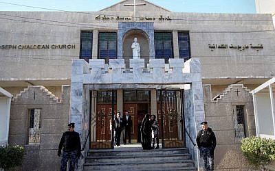 Iraqi police officers guard the entrance of St. Joseph's Chaldean Church before a Christmas mass in Baghdad, Iraq, Wednesday, Dec. 25, 2013. (photo credit: AP/Karim Kadim)