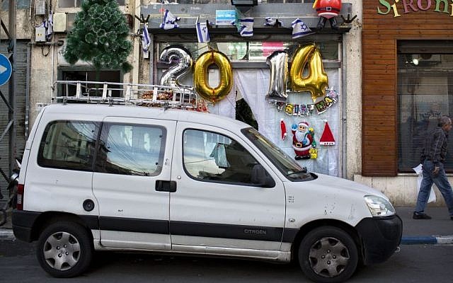 A man walks past a shop selling decorations ahead of New Year's Eve in Tel Aviv, Israel, Monday, Dec. 30, 2013. (AP Photo/Oded Balilty)