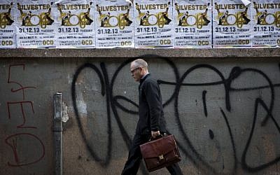 A man walks past posters advertising a New Year's Eve party in Tel Aviv, Israel, Monday, Dec. 30, 2013. In Israel, the somber, soul-searching and autumnal new year of the lunar Jewish calendar overshadows the Gregorian’s Jan. 1. (AP Photo/Oded Balilty)
