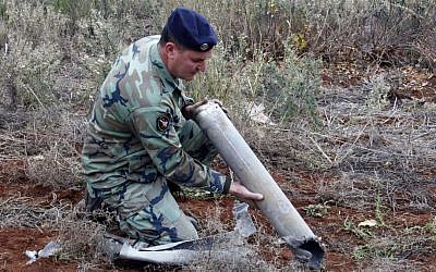 A Lebanese soldier holds remains of a rocket that was fired toward northern Israel in the southern village of Sarada, Lebanon, Sunday, Dec. 29, 2013.  (Photo credit: AP/Lotfallah Daher)