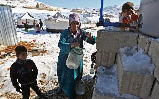 A Syrian refugee fetches water at a refugee camp in the eastern Lebanese border town of Arsal, Lebanon, on Sunday, December, 15, 2013. (photo credit: AP/Bilal Hussein) A Syrian refugee fetches water at a refugee camp in the eastern Lebanese border town of Arsal, Lebanon, on Sunday, December, 15, 2013. (photo credit: AP/Bilal Hussein)