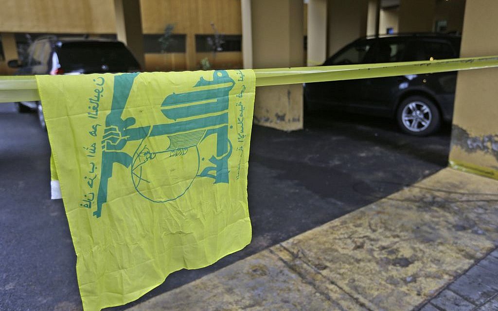 A Hezbollah flag hangs on yellow police tape sealing off the scene where Hassan al-Laqis, a senior commander for the Lebanese militant group Hezbollah, was gunned down outside his home, some two miles (three kilometers) southwest of Beirut, Lebanon on Wednesday, December 4, 2013. (photo credit: AP/Hussein Malla) A Hezbollah flag hangs on yellow police tape sealing off the scene where Hassan al-Laqis, a senior commander for the Lebanese militant group Hezbollah, was gunned down outside his home, some two miles (three kilometers) southwest of Beirut, Lebanon on Wednesday, December 4, 2013. (photo credit: AP/Hussein Malla)