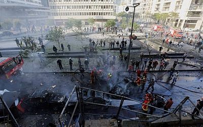 Lebanese firefighters extinguish burned vehicles at the scene of an explosion in Beirut, Lebanon, Friday, Dec. 27, 2013 (photo credit: AP/Bilal Hussein)