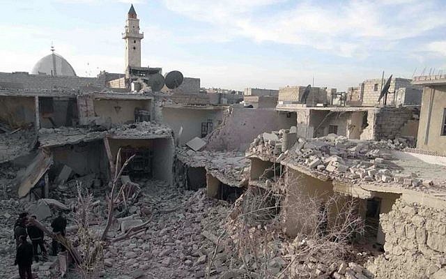 Syrian citizens stand on the rubble of houses that were destroyed by government airstrikes in Aleppo, Syria, Wednesday, Dec. 18, 2013 (photo credit: AP/Aleppo Media Center AMC) Syrian citizens stand on the rubble of houses that were destroyed by government airstrikes in Aleppo, Syria, Wednesday, Dec. 18, 2013 (photo credit: AP/Aleppo Media Center AMC)