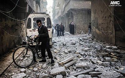 Residents inspect damaged buildings following government airstrikes in Aleppo, Syria, Dec. 23, 2013  (photo credit: AP/Aleppo Media Center AMC)