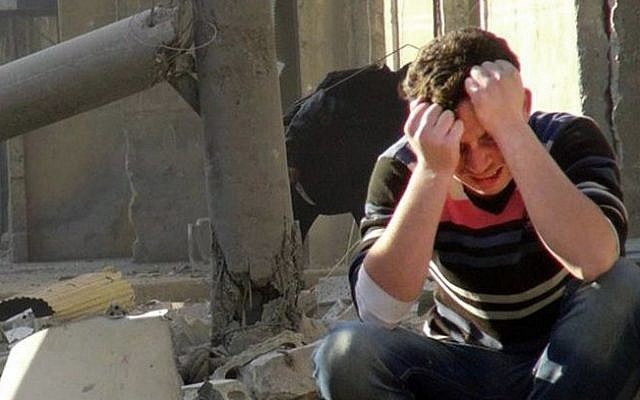 A Syrian man mourns as he sits in the rubble of buildings following a Syrian government airstrike in Aleppo, Syria. (Photo credit: AP Photo/Aleppo Media Center AMC)