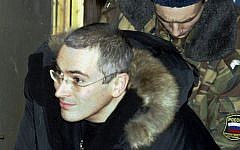 In this Dec. 23, 2003 file photo Mikhail Khodorkovsky, former chief of Russia's largest oil company, Yukos, center, is escorted by police officers as he leaves a court in Moscow, Russia (photo credit: AP/Sergey Ponomarev)