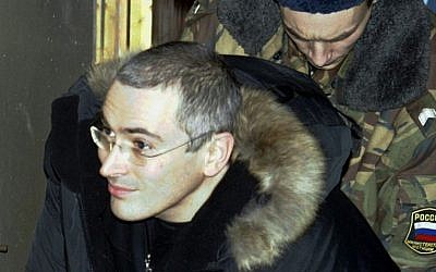 In this Dec. 23, 2003 file photo Mikhail Khodorkovsky, former chief of Russia's largest oil company, Yukos, center, is escorted by police officers as he leaves a court in Moscow, Russia (photo credit: AP/Sergey Ponomarev)