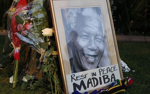 A framed portrait of former president Nelson Mandela and flowers are placed outside Mandela's Johannesburg home Friday, December 6, 2013. (photo credit: AP/Denis Farrell) A framed portrait of former president Nelson Mandela and flowers are placed outside Mandela's Johannesburg home Friday, December 6, 2013. (photo credit: AP/Denis Farrell)