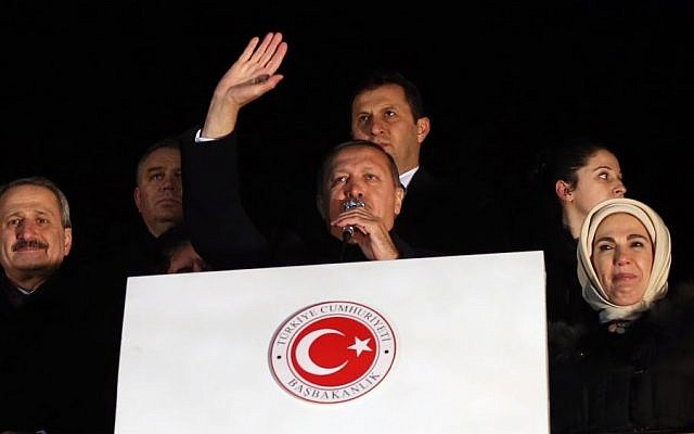 In this photo taken late Tuesday, Dec. 24, 2013, Turkey's Prime Minister Recep Tayyip Erdogan, center, is flanked by his wife Emine Erdogan, right, and Economy Minister Zafer Caglayan, left, as he addresses supporters at the Esenboga Airport, Ankara, Turkey. Interior Minister Muammer Guler and Caglayan resigned from their posts on Wednesday, Dec. 25, 2013, days after their sons were arrested in a massive corruption and bribery scandal that has targeted Erdogan’s allies and has become the worst crisis in his decade in power. Caglayan and Guler both stepped down on Wednesday, despite denying any wrongdoing. (Photo credit: AP) In this photo taken late Tuesday, Dec. 24, 2013, Turkey's Prime Minister Recep Tayyip Erdogan, center, is flanked by his wife Emine Erdogan, right, and Economy Minister Zafer Caglayan, left, as he addresses supporters at the Esenboga Airport, Ankara, Turkey. Interior Minister Muammer Guler and Caglayan resigned from their posts on Wednesday, Dec. 25, 2013, days after their sons were arrested in a massive corruption and bribery scandal that has targeted Erdogan’s allies and has become the worst crisis in his decade in power. Caglayan and Guler both stepped down on Wednesday, despite denying any wrongdoing. (Photo credit: AP)