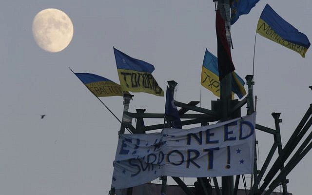 The moon rises over a metal base of destroyed metal Christmas trees decorated with Ukrainian national flags during a pro-European Union rally in Kiev's Independence Square, Saturday, December 14, 2013.(photo credit: AP/Dmitry Lovetsky) The moon rises over a metal base of destroyed metal Christmas trees decorated with Ukrainian national flags during a pro-European Union rally in Kiev's Independence Square, Saturday, December 14, 2013.(photo credit: AP/Dmitry Lovetsky)