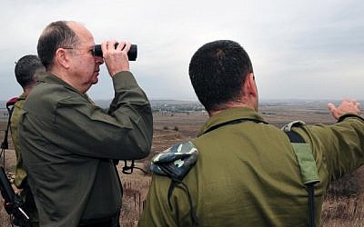 Israeli Defense Minister Moshe Ya'alon using binoculars to cast a glimpse to the Syrian territory from the Golan heights on December 3, 2013 (photo credit: Ariel Hermoni/Ministry of Defense/Flash 90)