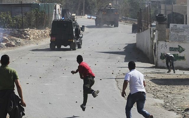 Illustrative photo of Palestinians throwing rocks at an Israeli vehicle in 2013. (photo credit: Issam Rimawi/Flash90) Illustrative photo of Palestinians throwing rocks at an Israeli vehicle in 2013. (photo credit: Issam Rimawi/Flash90)