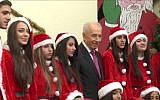 President Shimon Peres attempts to sing 'Jingle Bells' in a taped greeting for Christmas 2013 (screen capture: YouTube)