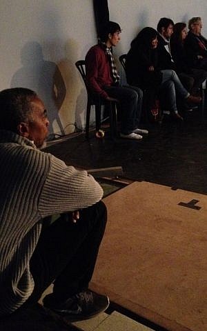 Choreographer Dean Moss sits and watches his students during the performance of their improvisational piece (photo credit: Jessica Steinberg/Times of Israel)