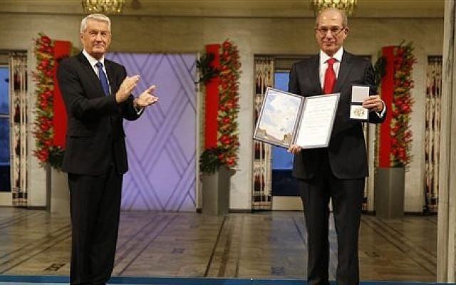 Ahmet Uzumcu, right, Director General of the Organization for the Prohibition of Chemical Weapons receives the Nobel Peace Prize from Chairman of the Norwegian Nobel Committee Thorbjorn Jagland in City Hall Oslo Tuesday Dec. 10, 2013 (photo credit: AP/Cornelius Poppe / NTB scanpix) Ahmet Uzumcu, right, Director General of the Organization for the Prohibition of Chemical Weapons receives the Nobel Peace Prize from Chairman of the Norwegian Nobel Committee Thorbjorn Jagland in City Hall Oslo Tuesday Dec. 10, 2013 (photo credit: AP/Cornelius Poppe / NTB scanpix)