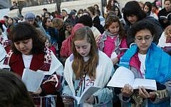 Eliza Moss-Horwitz, Lucy Sattler and Alexandra Schwartz pray with Women of the Wall. Schwartz (right) holds an empty Torah cover beneath her prayer book, symbolizing the Torah scroll the group was prevented from bringing in to the Kotel plaza, January 2014. (photo credit: Courtesy of Moving Traditions)