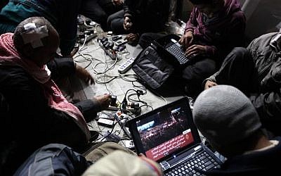 Egyptian anti-government bloggers work on their laptops from Cairo's Tahrir Square, on February 10, 2011 (photo credit: Patrick Baz/AFP)
