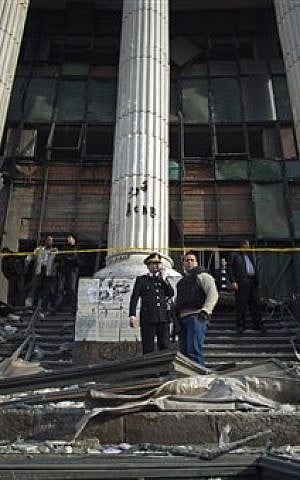 Egyptian police check the damage after an explosion at the Imbaba courthouse amid a massive security operation to protect polling stations, in Cairo, Egypt, Tuesday, Jan. 14, 2014. (photo credit: AP/Khalil Hamra)