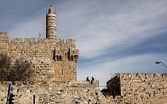 In this March 7, 2012 file photo, a couple sits next to the Tower of David on the wall surrounding Jerusalem's Old City. (AP/Sebastian Scheiner)