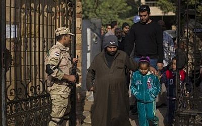 Egyptians walk into a polling center to vote in the country's constitutional referendum, in Cairo, Egypt, Wednesday, January 15, 2014 (photo credit: AP/Khalil Hamra)