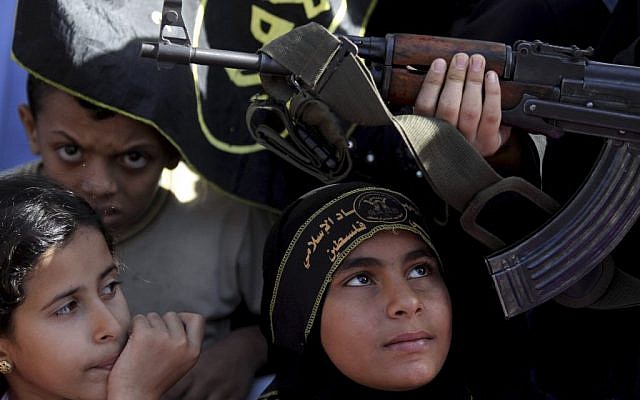 Palestinian children sit next to a woman holding a gun during an Islamic Jihad rally in Gaza City (photo credit: AP/Hatem Moussa) Palestinian children sit next to a woman holding a gun during an Islamic Jihad rally in Gaza City (photo credit: AP/Hatem Moussa)