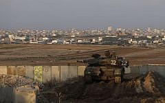 Illustrative. An Israeli tank parks in position overlooking the Gaza Strip on December 25, 2013. (AP/Tsafrir Abayov)