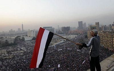 An Egyptian waves a national flag over a pro-military rally marking the third anniversary of the 2011 uprising in Tahrir Square in Cairo, Egypt, on Saturday, January 25, 2014. (AP/Amr Nabil)