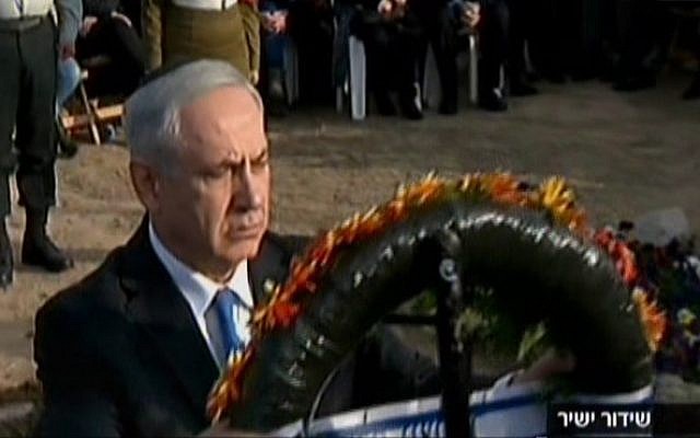 Prime Minister Benjamin Netanyahu lays a wreath at the grave of former premier Ariel Sharon, Monday, January 13, 2014. (photo credit: screen shot/Channel 2)