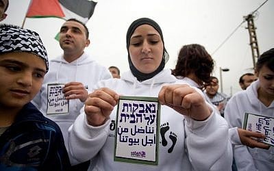 A Palestinian woman holds up a sign reading 'fighting for our homes' during a Land Day demonstration in Jaffa, April 2, 2011 (photo credit: Dima Vazinovich/Flash90)  