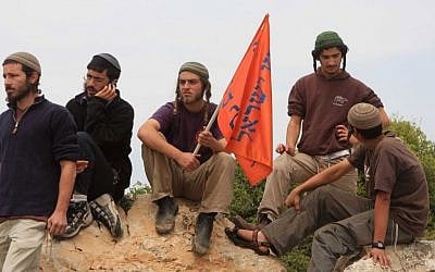 Jewish settlers watch as Israeli soldiers clash with Israeli and Palestinian activists during a demonstration against settlements in the West Bank town of Hebron (photo credit: Najeh Hashlamoun/Flash90)