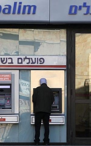 A Jerusalemite withdraws money from an ATM (Nati Shohat/Flash90) A Jerusalemite withdraws money from an ATM (Nati Shohat/Flash90)