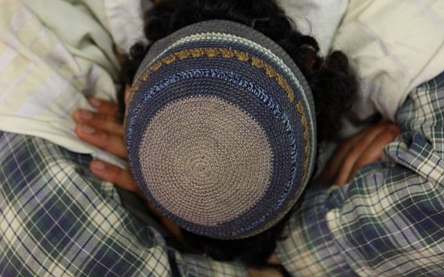 An Orthodox Jewish man seen wearing a knitted kippah as he prays. (photo credit: Yaakov Naumi/Flash90)