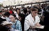 An Orthodox Jewish woman (left) prays alongside a young Jewish woman wearing tefillin at the Western Wall (photo credit: Miriam Alster/Flash90)