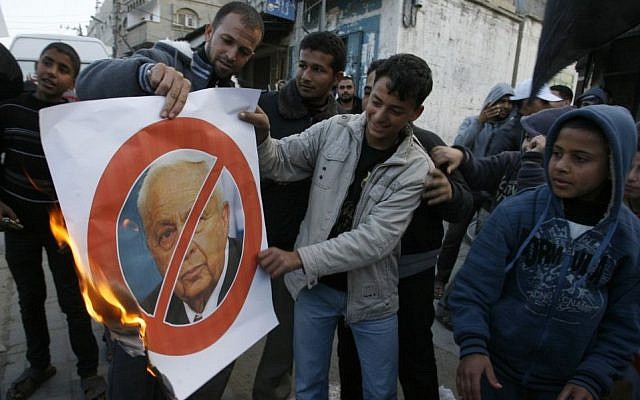 Palestinians in Khan Younis, Gaza Strip, burn crossed-out posters depicting late Israeli prime minister Ariel Sharon as they celebrate his death, January 11, 2014. (photo credit: Abed Rahim Khatib/Flash90) Palestinians in Khan Younis, Gaza Strip, burn crossed-out posters depicting late Israeli prime minister Ariel Sharon as they celebrate his death, January 11, 2014. (photo credit: Abed Rahim Khatib/Flash90)