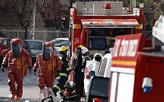 Rescue workers seen at the scene of the apartment treated with pesticides which poisoned an entire family in Jerusalem on Wednesday, January 22, 2014. (photo credit: Flash 90)