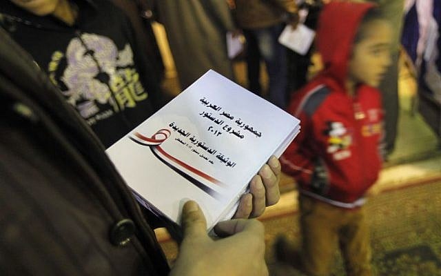 In this Thursday, Jan. 9, 2014 photo, an Egyptian Salafi holds a copy of the new constitution as he attends a conference to hear a lecture entitled “Know Your Constitution," ahead of a two-day vote on a draft amendment in El-Saf village, 50 kilometers (31 miles) south of Cairo, Egypt. (photo credit: AP/Amr Nabil) In this Thursday, Jan. 9, 2014 photo, an Egyptian Salafi holds a copy of the new constitution as he attends a conference to hear a lecture entitled “Know Your Constitution," ahead of a two-day vote on a draft amendment in El-Saf village, 50 kilometers (31 miles) south of Cairo, Egypt. (photo credit: AP/Amr Nabil)