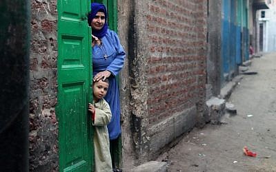 A Christian woman and her son stand in the doorway of their home in Dalga village of Minya, Egypt, Wednesday, January 15, 2014, on the second day of voting in the country's constitutional referendum (photo credit: AP/Roger Anis, El Shorouk Newspaper)