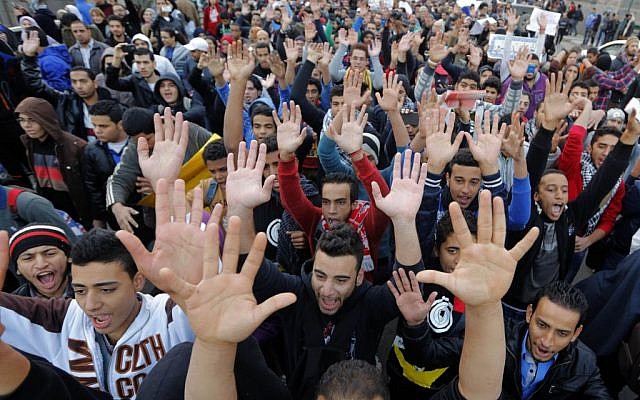 Egyptian protesters wave their hands as the chant anti-police and military slogans during a march towards the Egyptian Cabinet to commemorate the 2nd anniversary of the 2011 Cabinet clashes, on Kasr el-Nile bridge in Cairo, Egypt. December 16, 2013 (photo credit: AP Photo/Amr Nabil) Egyptian protesters wave their hands as the chant anti-police and military slogans during a march towards the Egyptian Cabinet to commemorate the 2nd anniversary of the 2011 Cabinet clashes, on Kasr el-Nile bridge in Cairo, Egypt. December 16, 2013 (photo credit: AP Photo/Amr Nabil)