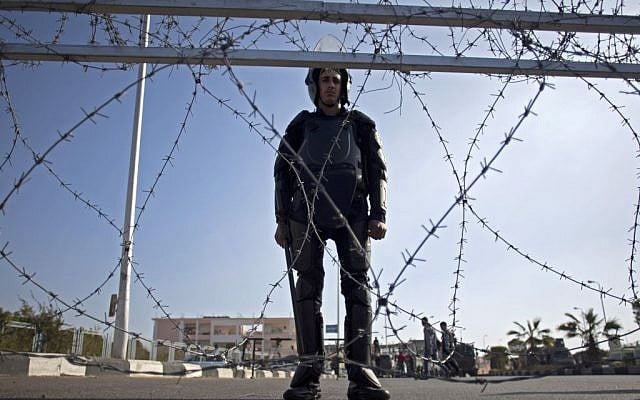 A policeman stands guard outside a courthouse during the trial of Egypt's toppled President Mohammed Morsi in Cairo, Egypt, Tuesday, Jan. 28, 2014. (photo credit: AP/Khalil Hamra)