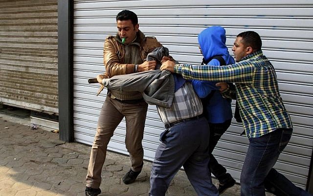 Egyptian plainclothes policemen arrest a supporter of ousted Islamist president Mohammed Morsi during clashes in Cairo, Egypt, on Friday (photo credit: AP/Ahmed Abd El Latif/El Shorouk newspaper) Egyptian plainclothes policemen arrest a supporter of ousted Islamist president Mohammed Morsi during clashes in Cairo, Egypt, on Friday (photo credit: AP/Ahmed Abd El Latif/El Shorouk newspaper)