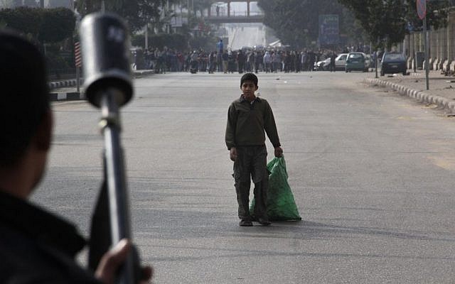 A boy looks at Egypt's security forces as they try to disperse supporters of ousted President Mohammed Morsi in Cairo, Egypt, Friday, Jan. 17, 2014. (photo credit: AP/Aly Hazzaa) A boy looks at Egypt's security forces as they try to disperse supporters of ousted President Mohammed Morsi in Cairo, Egypt, Friday, Jan. 17, 2014. (photo credit: AP/Aly Hazzaa)