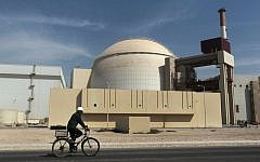 A worker rides a bicycle in front of the reactor building of the Bushehr nuclear power plant, just outside the southern city of Bushehr, Iran,  Oct. 26, 2010. (AP/Mehr News Agency, Majid Asgaripour)