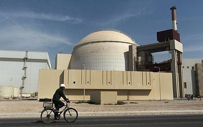 A worker rides a bicycle in front of the reactor building of the Bushehr nuclear power plant, just outside the southern city of Bushehr, Iran,  Oct. 26, 2010. (AP/Mehr News Agency, Majid Asgaripour)